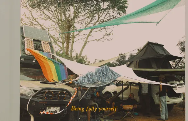 Being fully yourself. Campers relaxing under awnings beside their vehicles.