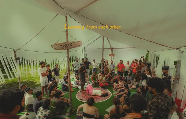 Learning from each other. A workshop circle gathered inside a white tent.
