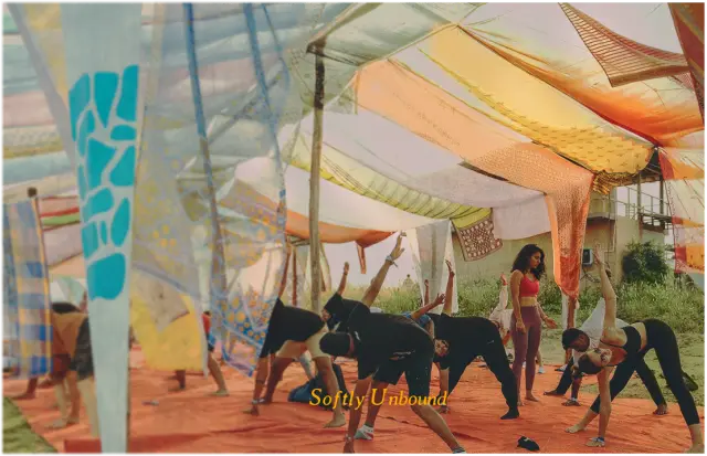 Softly unbound. A yoga session under a canopy of coloured fabric.